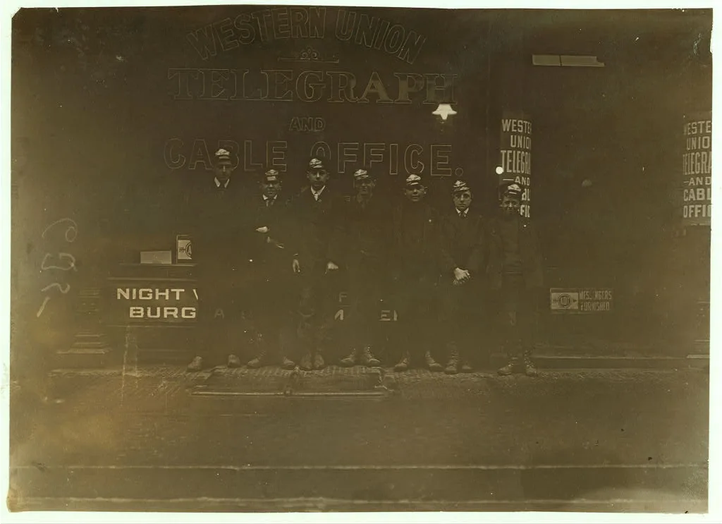A group of messenger boys. These work until 11 P.M.  Location:…, Connecticut, 1909