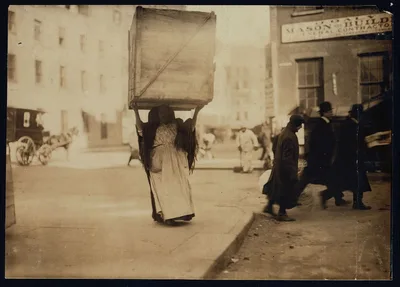 Italian woman carrying an enormous empty dry-goods-box for some…, New York (State), 1912