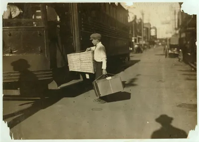 Young delivery boy with heavy bundles.  Location: Mobile, Alabama, 1914