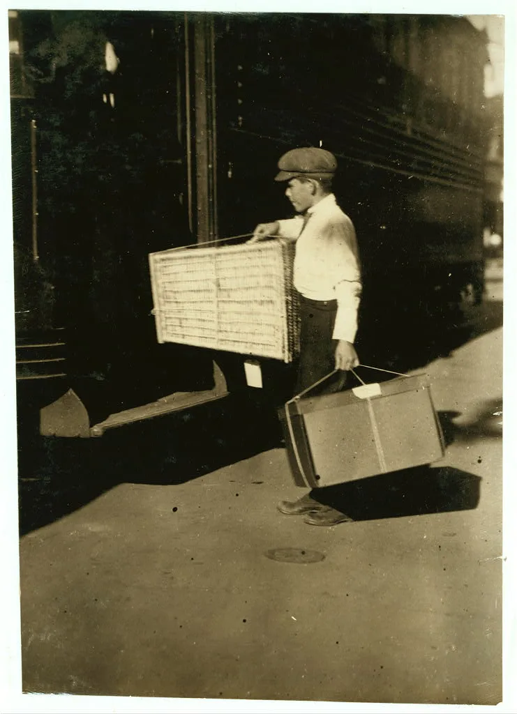 Young delivery boy with heavy bundles.  Location: Mobile, Alabama, 1914