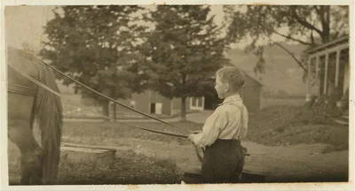 Eight-year old Jack carrying cans of milk on stone boat. This…, Massachusetts, 1915