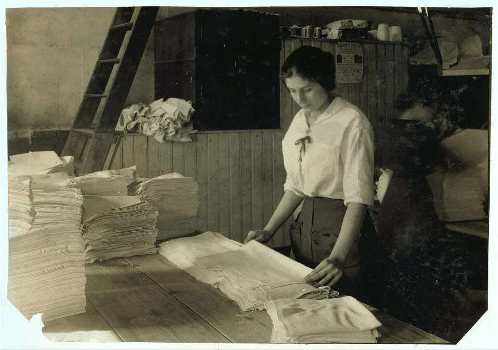 [15-year old girl folding towels in Bonanno Laundry.]  Location:…, Massachusetts, 1917